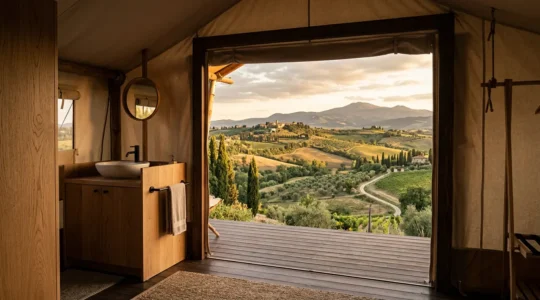 Vista dall'interno di una lussuosa tenda glamping con bagno privato, mostrando il contrasto tra comfort moderno e natura selvaggia