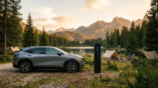 Auto elettrica in carica presso colonnina di un campeggio immerso nella natura