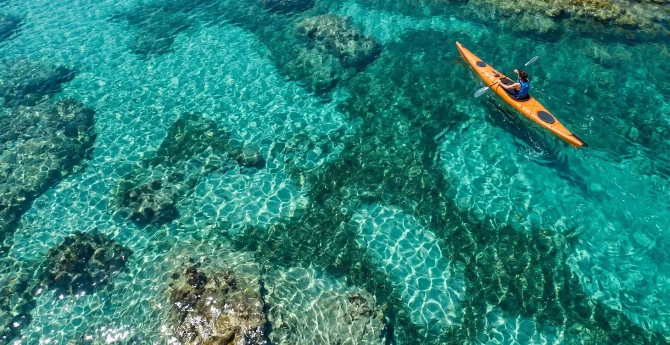 Vista aerea di kayak che esplora una caletta nascosta con acque turchesi in Sardegna